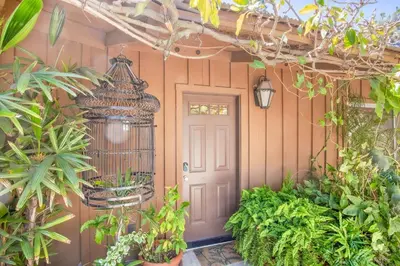 a front door of a house with a bird cage at Nature lovers wellness home in Fallbrook