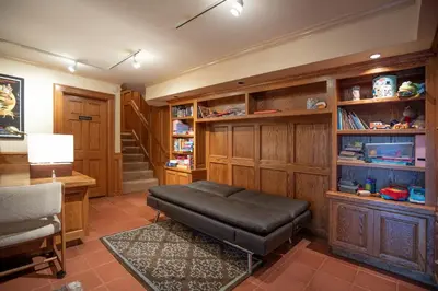 a living room with a bench and a desk and shelves at Nature lovers wellness home in Fallbrook