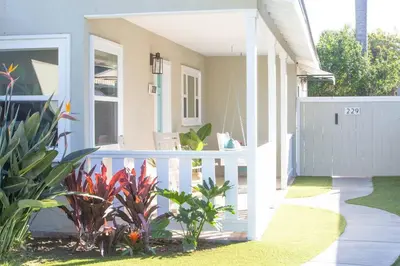 a house with a white fence and some plants at Live the Beach Life in a Quaint Shell Cottage in Del Mar