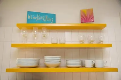 a shelf with plates and wine glasses on it at Geometric Loft: renovated, hip, pets, pool/spa in Solana Beach