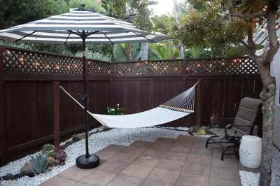 a hammock under an umbrella on a fence at Geometric Loft: renovated, hip, pets, pool/spa in Solana Beach