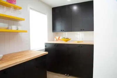 a kitchen with black cabinets and a yellow bowl on the counter at Geometric Loft: renovated, hip, pets, pool/spa in Solana Beach