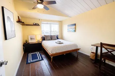 a bedroom with a bed and a ceiling fan at Sunset Haven: Lakeside Charm in Ocean Beach in San Diego