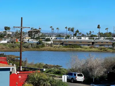a white truck parked next to a river with a train at Sunset Haven: Lakeside Charm in Ocean Beach in San Diego