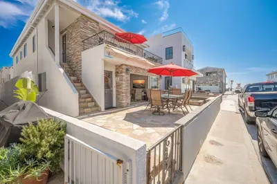 a house with a balcony with a table and an umbrella at Three Bedroom Home on 36th with Indoor Outdoor Living in Newport Beach