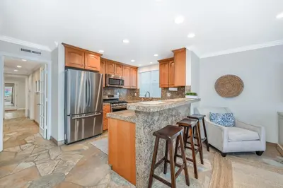 a kitchen with wooden cabinets and a counter top at Three Bedroom Home on 36th with Indoor Outdoor Living in Newport Beach