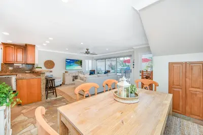 a kitchen and living room with a wooden table and chairs at Three Bedroom Home on 36th with Indoor Outdoor Living in Newport Beach