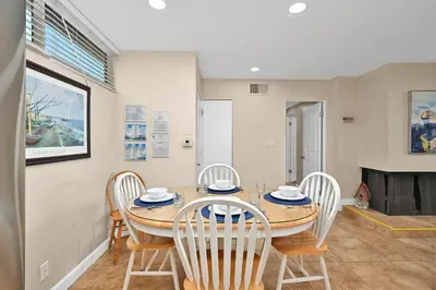 a dining room with a table and chairs and a fireplace at Three Bedroom Three Bath Home w Patio 1 block from beach in Newport Beach