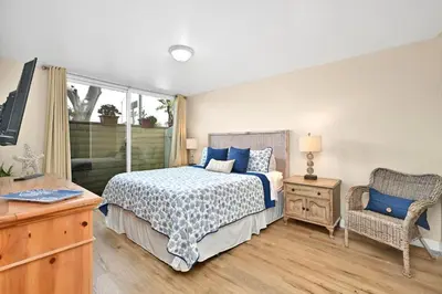 a bedroom with a bed and a chair at Three Bedroom Three Bath Home w Patio 1 block from beach in Newport Beach