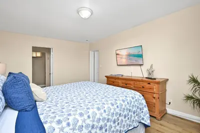 a bedroom with a bed and a wooden dresser at Three Bedroom Three Bath Home w Patio 1 block from beach in Newport Beach