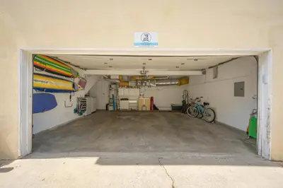 a garage with a door open to a room with surfboards at Three Bedroom Three Bath Home w Patio 1 block from beach in Newport Beach