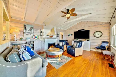 a living room with a couch and a tv at Oceanfront Dog Friendly Home with Waterfront Porch, Gas Grill, Hot Tub & Fire Pit in San Diego