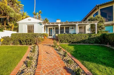 a house with a brick walkway in front of it at Oceanfront Dog Friendly Home with Waterfront Porch, Gas Grill, Hot Tub & Fire Pit in San Diego