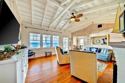 a kitchen and living room with a ceiling fan at Oceanfront Dog Friendly Home with Waterfront Porch, Gas Grill, Hot Tub & Fire Pit in San Diego