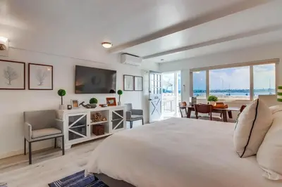 a bedroom with a large bed and a dining room at Bayside 1 in San Diego