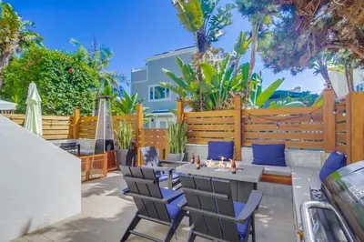 a patio with a table and chairs and a fence at Contempo Coastal in San Diego