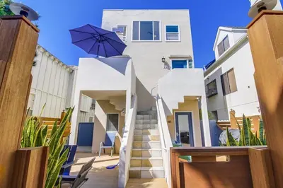 a white building with a staircase and an umbrella at Contempo Coastal in San Diego