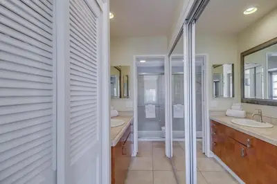 a white bathroom with two sinks and a shower at Contempo Coastal in San Diego