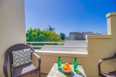 a table with two chairs and two bottles on a balcony at Contempo Coastal in San Diego