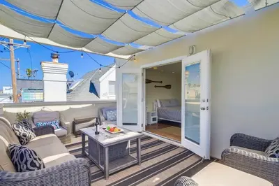 a patio with chairs and a table on a deck at Contempo Coastal in San Diego