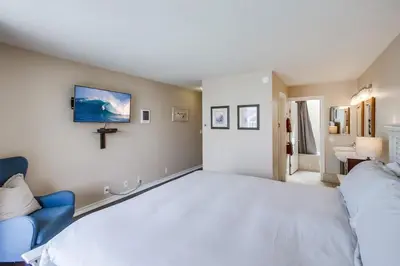 a bedroom with a large white bed and a cross on the wall at Waterfront 1 in San Diego