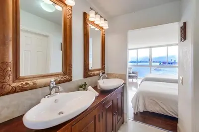 a bathroom with two sinks and a bed and a mirror at Waterfront 1 in San Diego