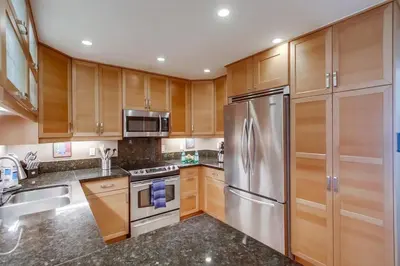 a kitchen with wooden cabinets and a stainless steel refrigerator at Waterfront 1 in San Diego