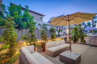 a patio with two white couches and an umbrella at Sand & Sea in San Diego