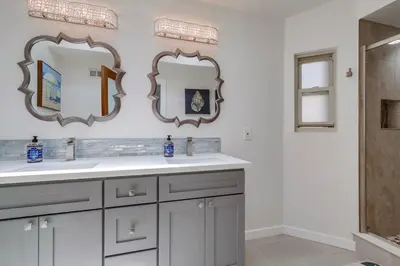 a bathroom with two mirrors and a sink at Sand & Sea in San Diego
