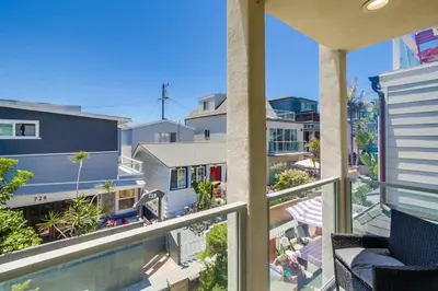 an apartment balcony with a swimming pool and buildings at Sand & Sea in San Diego
