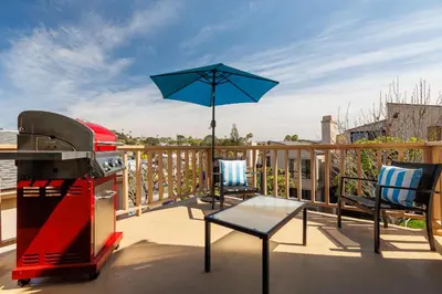 a patio with a grill and an umbrella on a deck at SB-503 - Cali Surfer Lounge in Solana Beach
