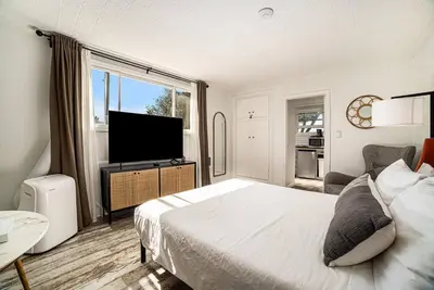 a bedroom with a bed and a flat screen tv at Cozy Studio with Outdoor Oasis in Bonita