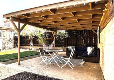 a patio with a table and chairs under a wooden pergola at Cozy Studio with Outdoor Oasis in Bonita