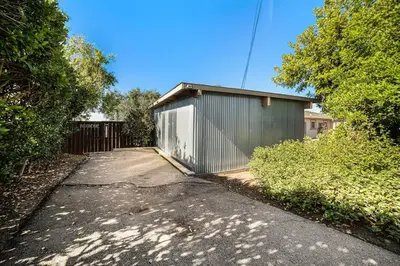 a building with a gate on the side of a driveway at Cozy Studio with Outdoor Oasis in Bonita