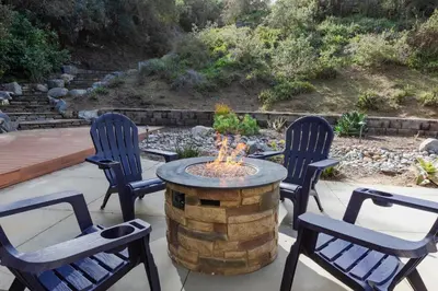 four chairs around a circular table with a fire pit at Elite Retreat! Hot Tub, Arcade, & Theater. 6 Beds! in Encinitas