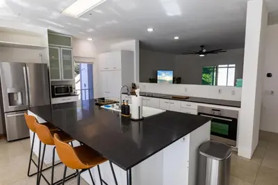 a kitchen with a black counter top and white cabinets at Elite Retreat! Hot Tub, Arcade, & Theater. 6 Beds! in Encinitas
