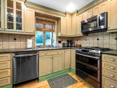 a kitchen with wooden cabinets and stainless steel appliances at Ocean-View Mountaintop Getaway. Jacuzzi/Ping-Pong! in San Diego