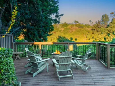 a wooden deck with chairs and a table with a fire at Cozy Getaway. Fire Pit and Endless Views! 5 Beds in San Diego