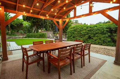 a wooden table and chairs under a wooden pergola at Cozy Getaway. Fire Pit and Endless Views! 5 Beds in San Diego