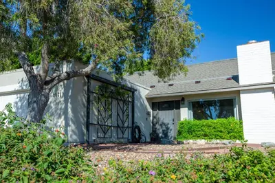 a house with a garage with a tree at Cozy Getaway. Fire Pit and Endless Views! 5 Beds in San Diego