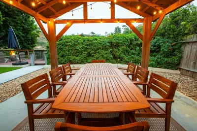 a wooden table and chairs under a wooden pergola at Cozy Getaway. Fire Pit and Endless Views! 5 Beds in San Diego