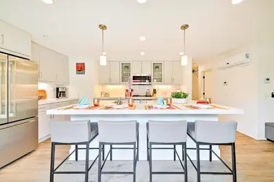 a kitchen with white cabinets and a large island with bar stools at Bayside Cove 5 in San Diego