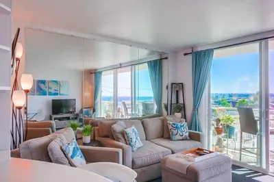 a living room with a couch and a large window at Penthouse in San Diego