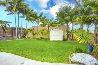 a yard with palm trees and a white garage at Grandview 2 in Encinitas