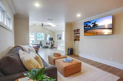 a living room with a couch and a tv on a wall at Grandview 2 in Encinitas