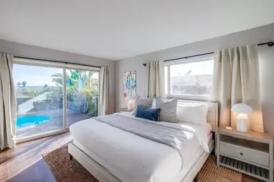a bedroom with a large bed and a large window at Tropical Retreat in San Diego