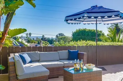 a patio with a couch and an umbrella at Tropical Retreat in San Diego