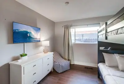 a bedroom with a bed and a white dresser and a couch at Tropical Retreat in San Diego