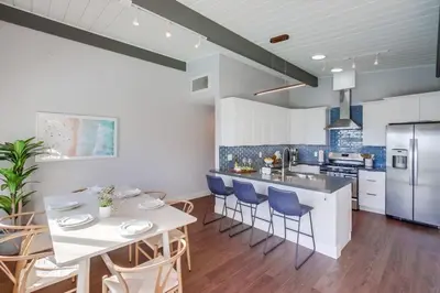 a kitchen with a table and chairs and a refrigerator at Tropical Retreat in San Diego