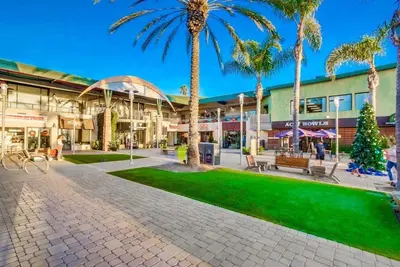 a shopping mall with palm trees in front of it at Seaside in Cardiff-by-the-Sea